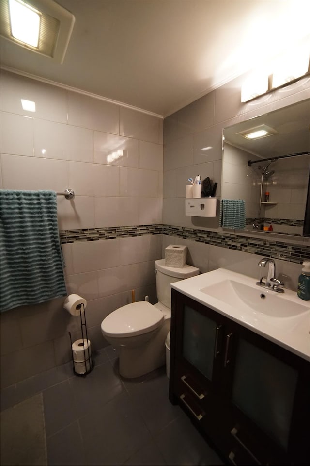full bathroom featuring vanity, toilet, tile patterned floors, tile walls, and decorative backsplash