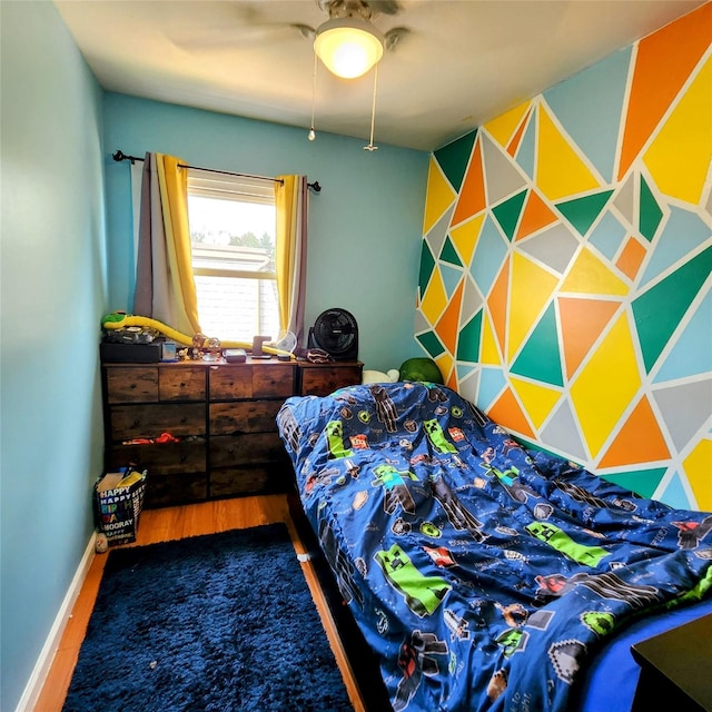 bedroom featuring baseboards, a ceiling fan, and wood finished floors