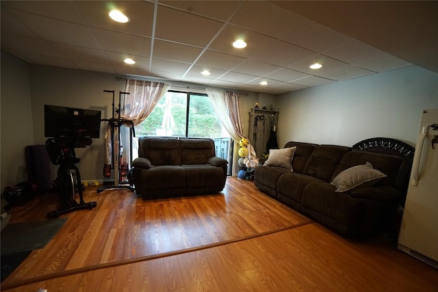 living area with recessed lighting, a drop ceiling, and wood finished floors