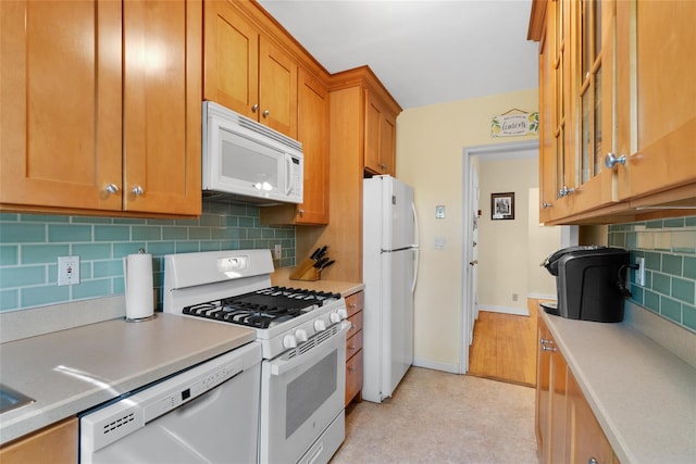 51 Rockledge Rd Unit 1A, Hartsdale, NY 10530 - kitchen featuring white appliances, light countertops, tasteful backsplash, and brown cabinetry