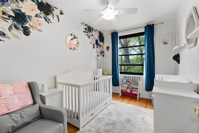 51 Rockledge Rd Unit 1A, Hartsdale, NY 10530 - bedroom with a nursery area, light wood finished floors, and a ceiling fan