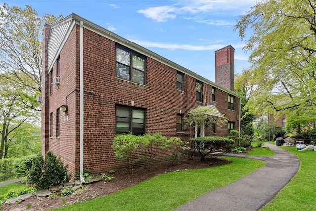 51 Rockledge Rd Unit 1A, Hartsdale, NY 10530 - view of home's exterior featuring a chimney, brick siding, a lawn, and cooling unit