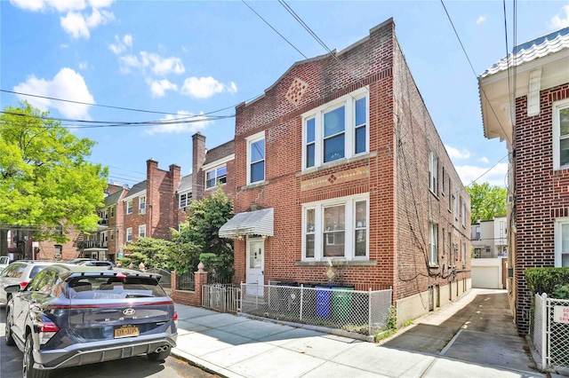 townhome / multi-family property with brick siding, central AC unit, a residential view, and fence private yard