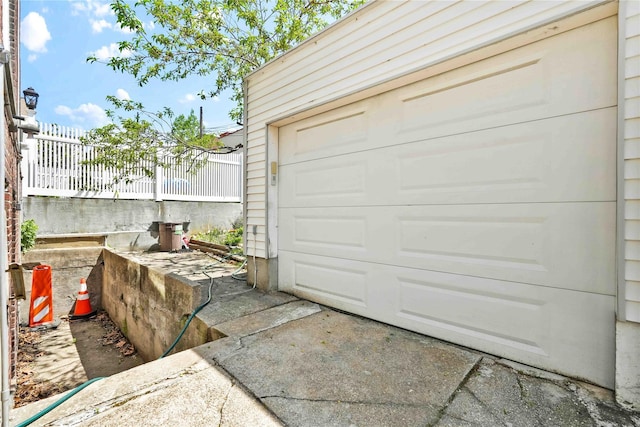 garage with fence and driveway