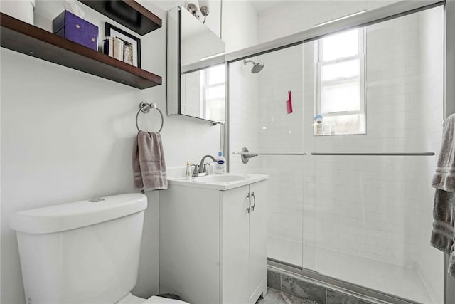 full bathroom featuring vanity, a shower stall, and toilet