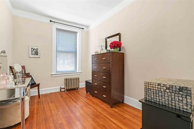 living area featuring light wood-style floors, radiator, and baseboards