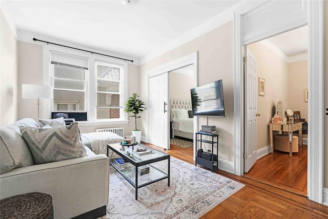 living room with crown molding, baseboards, and radiator