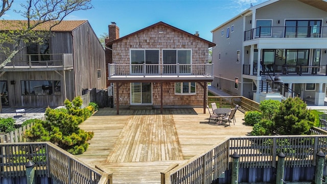 208 Block Ln, Harbor Isle, NY 11558 - rear view of house with a balcony, outdoor dining space, and a wooden deck