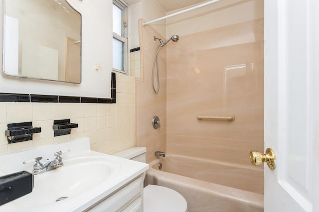bathroom featuring toilet, decorative backsplash, tile walls, bathing tub / shower combination, and vanity