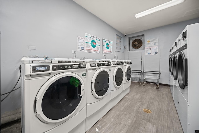 common laundry area with washing machine and dryer and light wood-type flooring