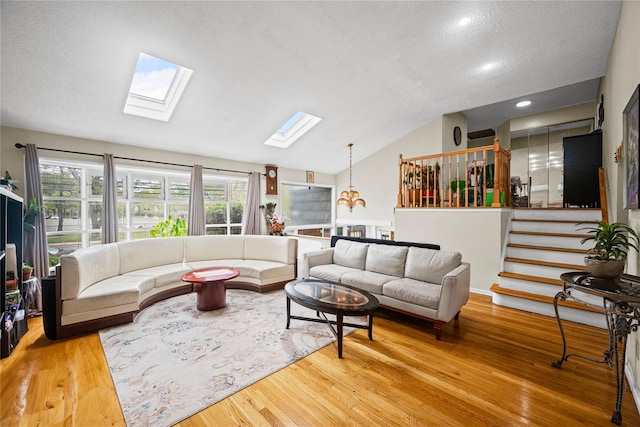211 Cantiague Rock Rd, Westbury, NY 11590 - living room featuring a healthy amount of sunlight, wood finished floors, vaulted ceiling with skylight, and a textured ceiling