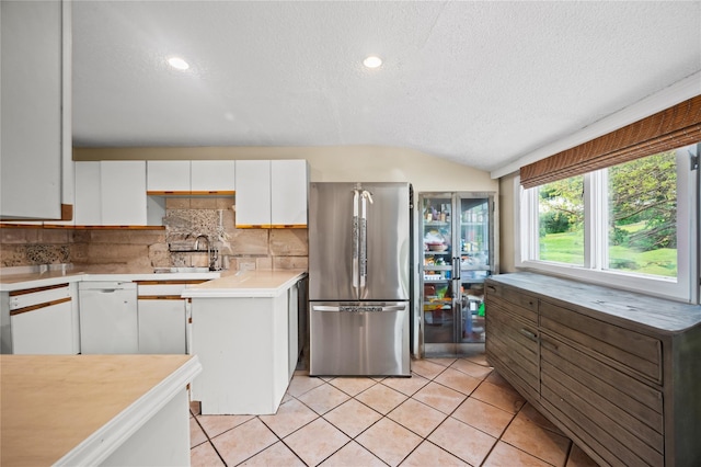 211 Cantiague Rock Rd, Westbury, NY 11590 - kitchen with freestanding refrigerator, a textured ceiling, backsplash, and white cabinets