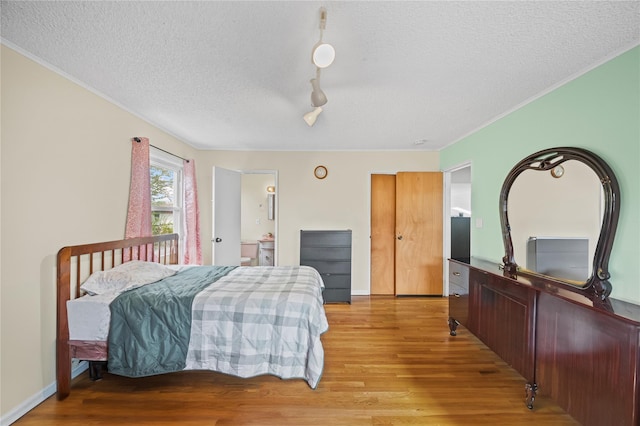 211 Cantiague Rock Rd, Westbury, NY 11590 - bedroom with light wood-style floors, crown molding, and a textured ceiling