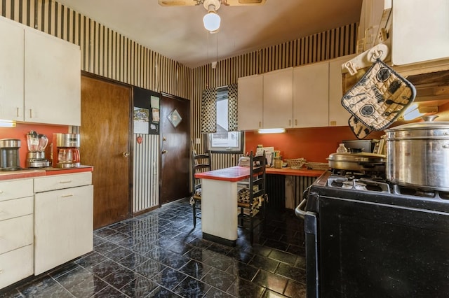 84-52 123rd St, Kew Gardens, NY 11415 - kitchen featuring gas stove, ceiling fan, wallpapered walls, tile countertops, and cream cabinetry