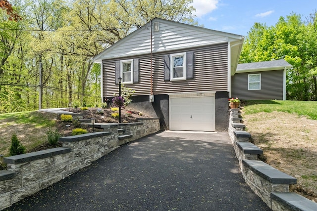 view of front of house with asphalt driveway and a garage