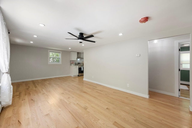 unfurnished living room featuring a ceiling fan, light wood finished floors, recessed lighting, and baseboards