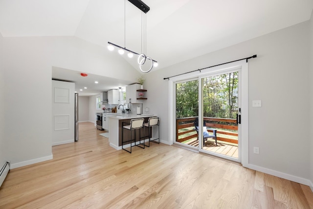 kitchen featuring stainless steel electric range oven, a breakfast bar, open shelves, white cabinets, and light countertops
