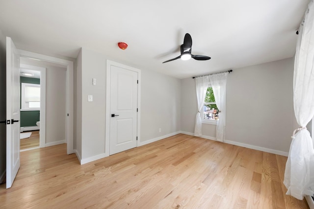 unfurnished bedroom with light wood-style flooring, baseboards, and ceiling fan