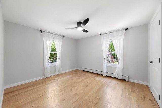 empty room featuring light wood-type flooring, ceiling fan, a baseboard radiator, and baseboards