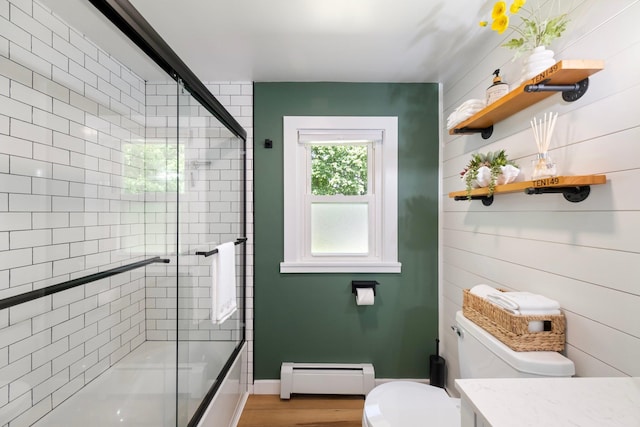 full bathroom featuring baseboard heating, toilet, wood finished floors, baseboards, and vanity