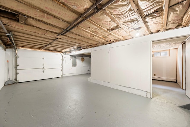 garage with a baseboard heating unit and electric panel
