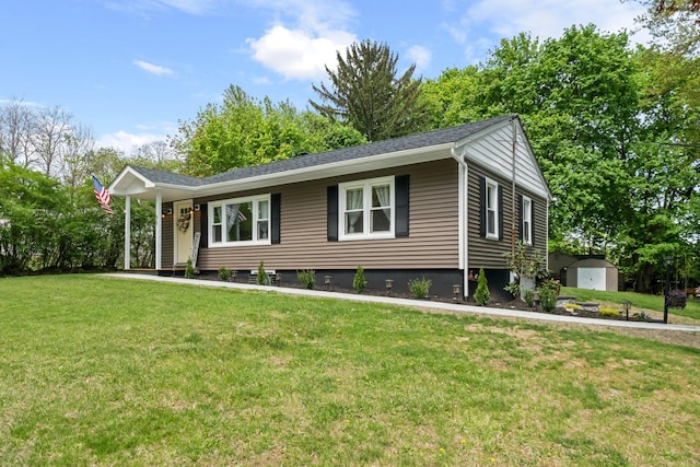 ranch-style home featuring a front yard, a shed, and an outbuilding