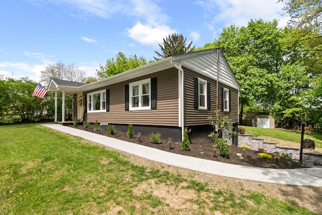 view of side of home with a shed, a yard, and an outdoor structure