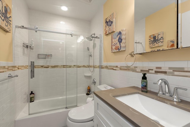 full bath featuring tile walls, toilet, shower / bath combination with glass door, vanity, and recessed lighting