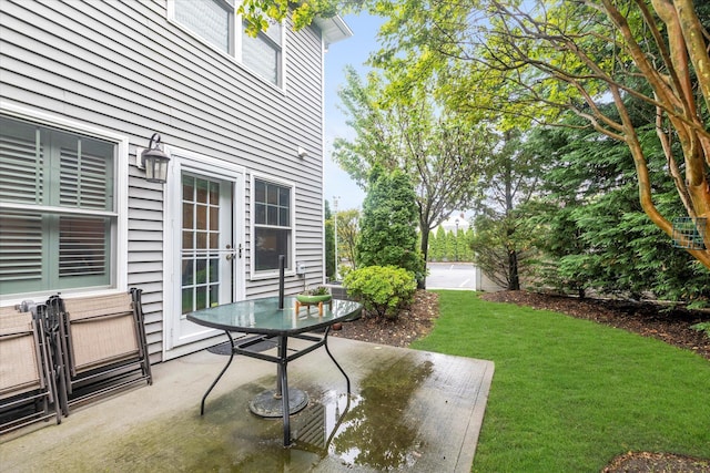 view of grassy yard featuring a patio and outdoor dining area