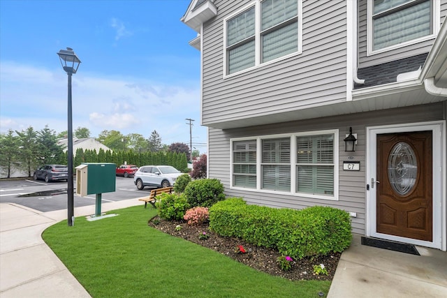 doorway to property featuring a lawn