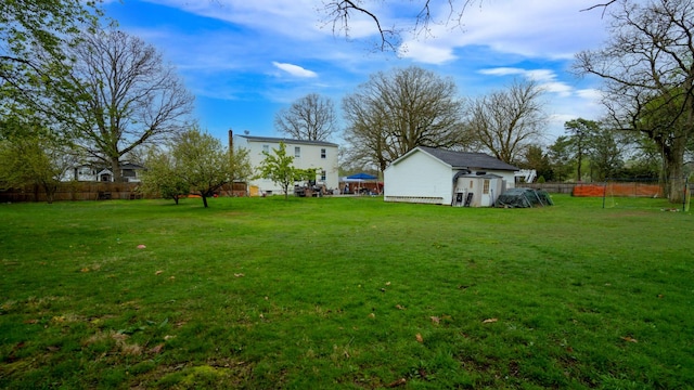 view of yard with fence, an outdoor structure, and a shed