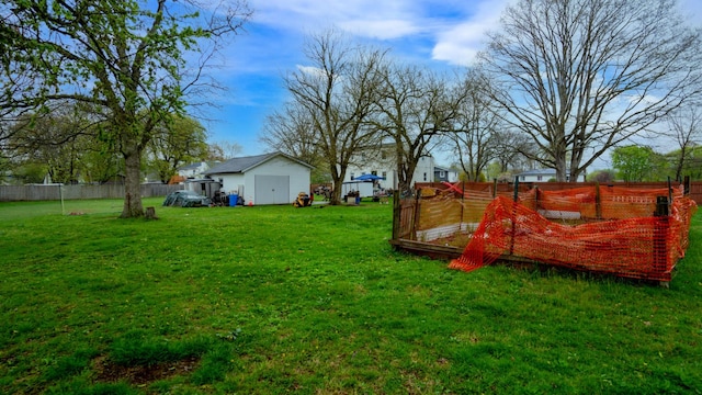 view of yard with an outdoor structure, fence, and a shed