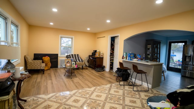 sitting room featuring arched walkways, recessed lighting, and wood finished floors