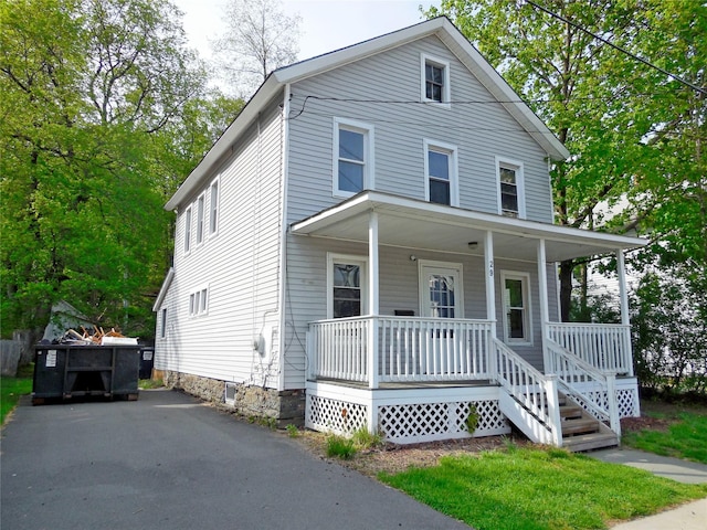traditional style home with covered porch and aphalt driveway