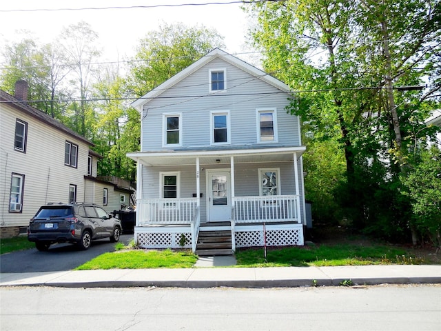 american foursquare style home featuring covered porch