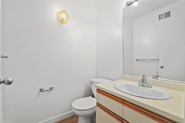 half bathroom featuring visible vents, vanity, toilet, baseboards, and tile patterned floors