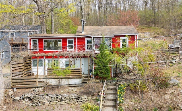 view of front of home with a forest view