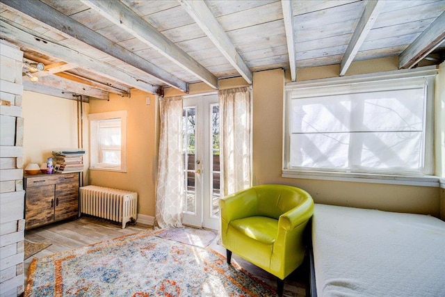 sitting room featuring beam ceiling, french doors, radiator heating unit, wooden ceiling, and wood finished floors