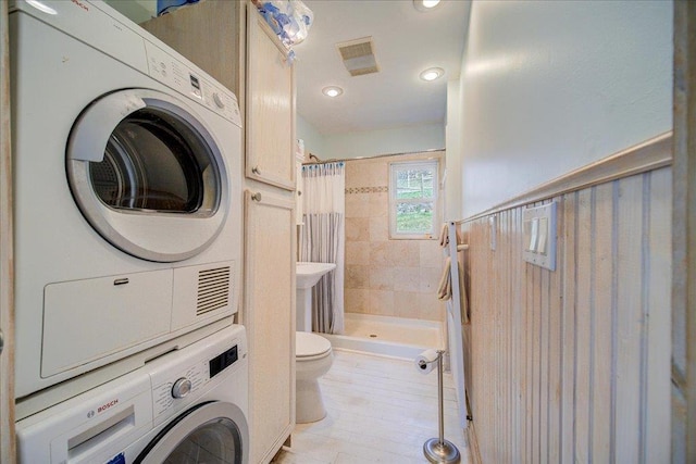 full bathroom with visible vents, stacked washer / dryer, toilet, recessed lighting, and a shower stall