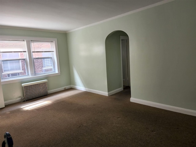 carpeted spare room featuring radiator, ornamental molding, baseboards, and arched walkways
