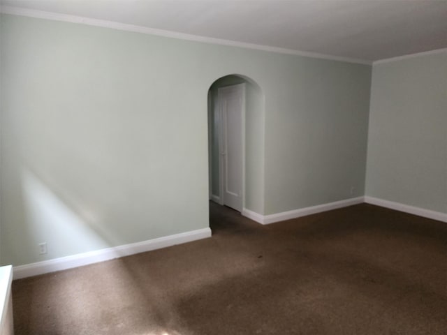 carpeted spare room with baseboards, ornamental molding, and arched walkways