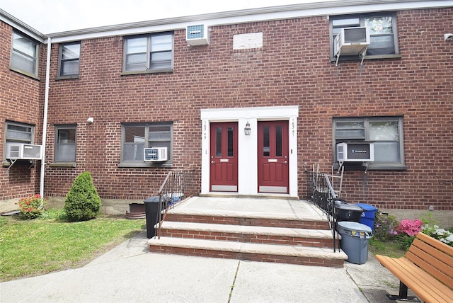 entrance to property with cooling unit and brick siding