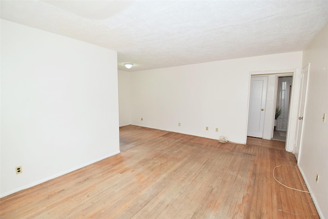 unfurnished room featuring baseboards and light wood-style flooring