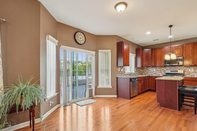 kitchen featuring stainless steel appliances, light wood-style flooring, tasteful backsplash, baseboards, and recessed lighting