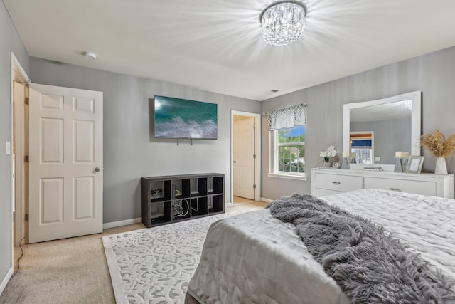 bedroom with light carpet, baseboards, and a chandelier