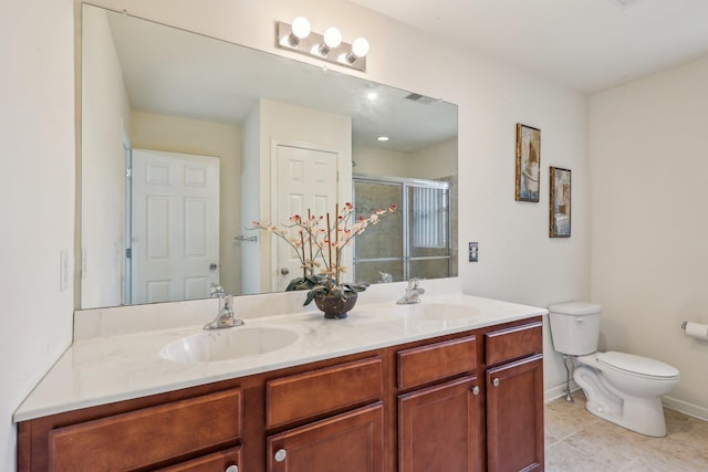 bathroom with toilet, a shower stall, double vanity, tile patterned floors, and baseboards