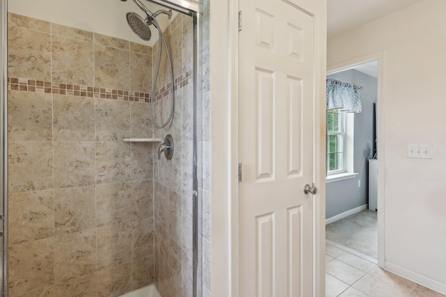 bathroom with a shower stall, baseboards, and tile patterned floors