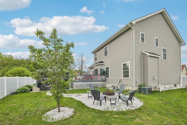 rear view of property with an outdoor fire pit, central AC unit, and a deck