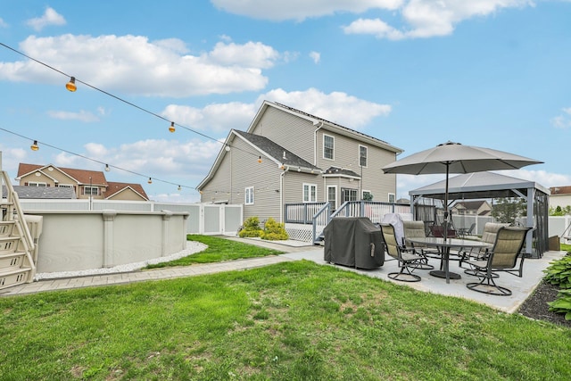 back of property featuring a gazebo, a patio, and a deck