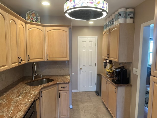 kitchen featuring a sink, light brown cabinets, and tasteful backsplash